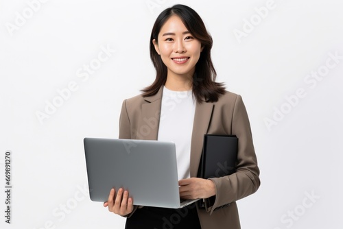 Cheerful beautiful freelancer dressed in elegant suit working on project. Young professional woman entrepreneur laughing and checking e-mails on laptop while standing on white background.