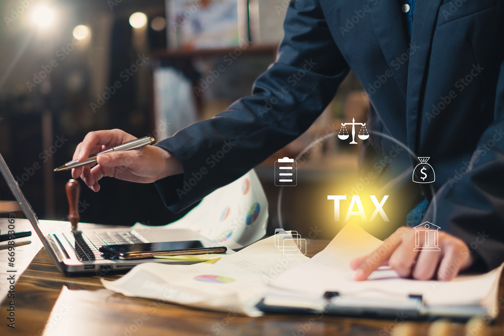 Businessman work on tax paper document, mobile phone and laptop to