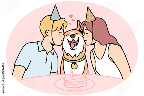 Girl, guy sit at festive table with cake, kiss happy dog in center. Family canine pet celebrates his first birthday surrounded by loving young owners in party hats. Vector colored linear illustration. photo