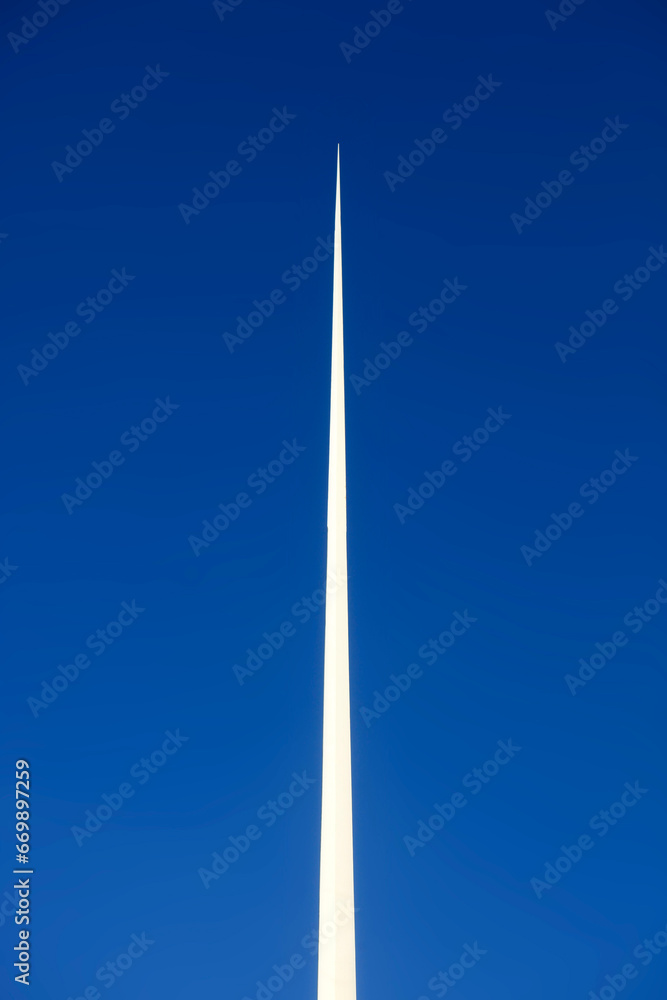 White pointed needle on blue sky background