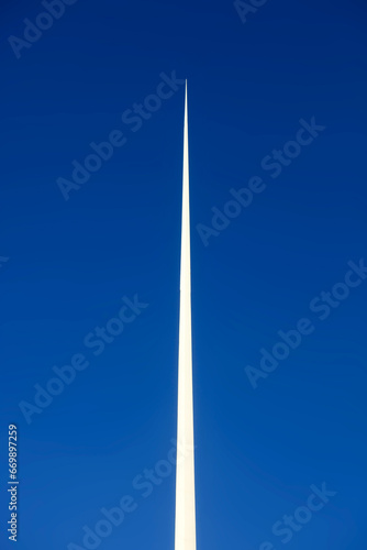 White pointed needle on blue sky background