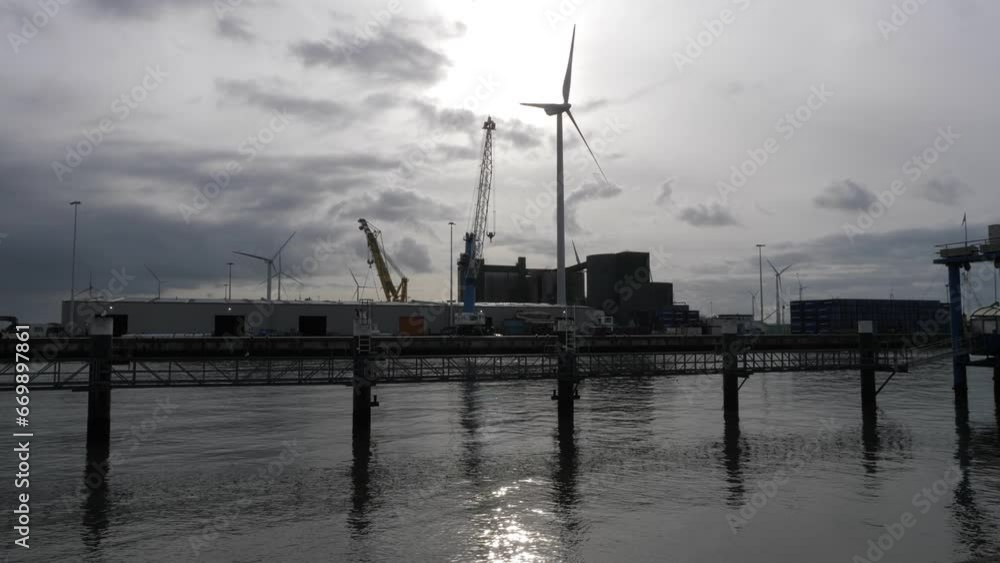 Harbor Eemshaven in the Netherlands with windmill and crane, backlight Harbor Eemshaven in the Netherlands with windmill and crane, backlight