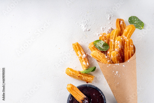 Traditional Spanish dessert churros with sugar powder and chocolate sauce