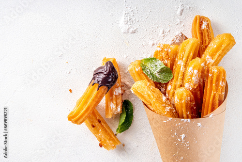 Traditional Spanish dessert churros with sugar powder and chocolate sauce