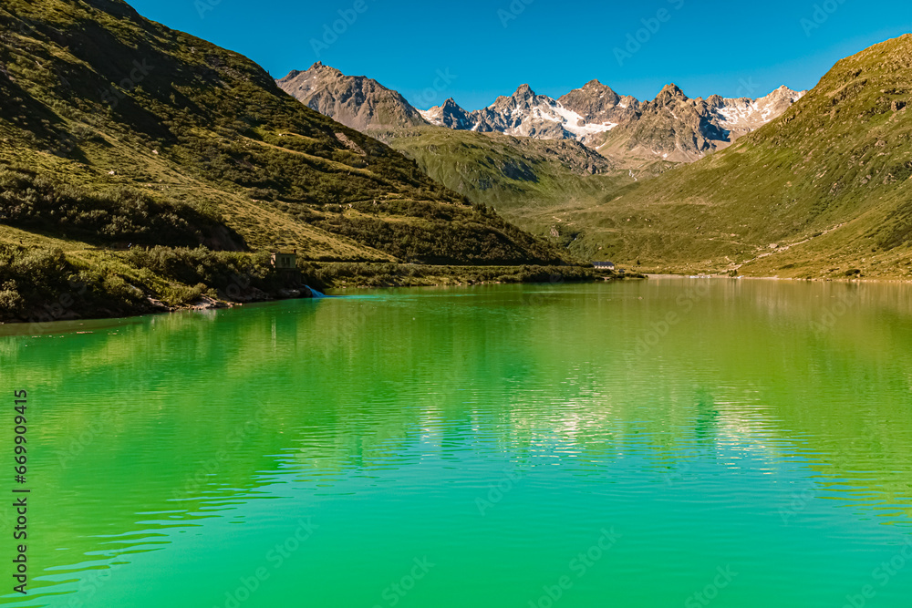 Alpine summer view with reflections in a lake at Vermunt reservoir, Sylvretta-High-Alps-Street, Vorarlberg, Tyrol, Austria