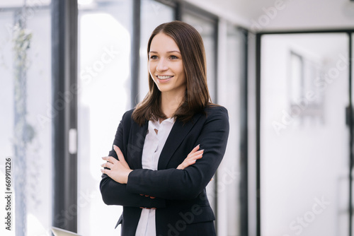 portrait of a business woman Self-confident young woman standing holding coffee mug and working tablet. People. Straightforward portrait.