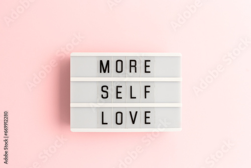 фотографія More self love. White lightbox with letters on a pink background.