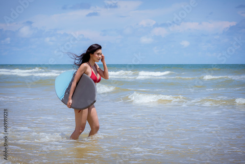 Fototapeta Naklejka Na Ścianę i Meble -  Asian woman surfer in sexi bikini holding surfboard playing on tropical beach at summer enjoy outdoor activity lifestyle water sport extreme surfing on travel vacation concept.