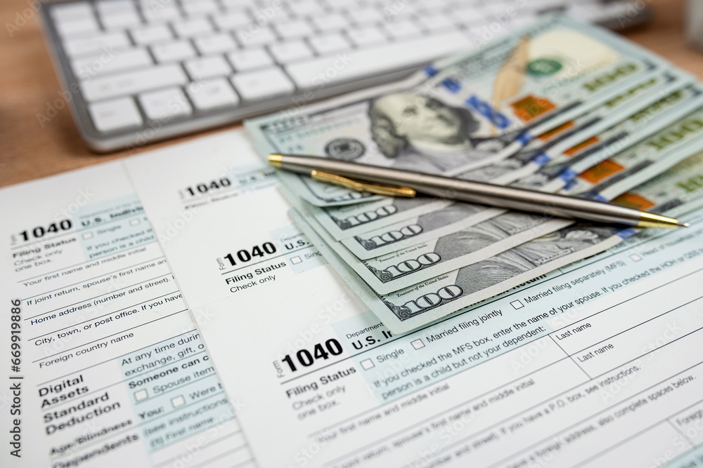 Obraz premium Tax payment with 1040 form pen and dollar bills