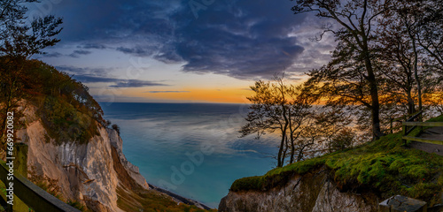 Dawn over the stunning white chalk cliffs of Møn island. Sunrise over the enchanting Møn island on the Danish coast, casting a magical light on the majestic white chalk cliffs, Møns Klint.  photo