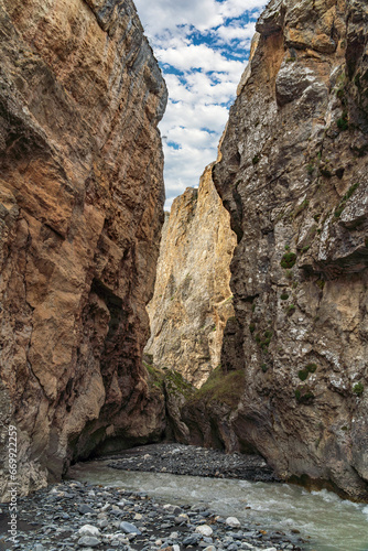 A fast mountain river flows into a mountain gorge