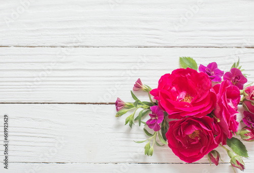 pink and red roses on white wooden background © Maya Kruchancova