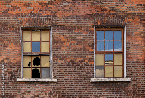 Broken windows on the brown brick wall
