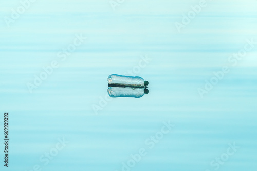 Empty plastic bottle floating on water  environmental damage and pollution concept