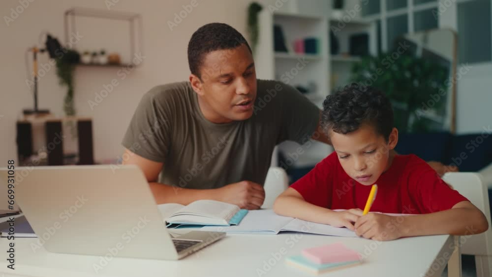 African American father and son doing school homework together, family support African American father and son doing school homework together, family support