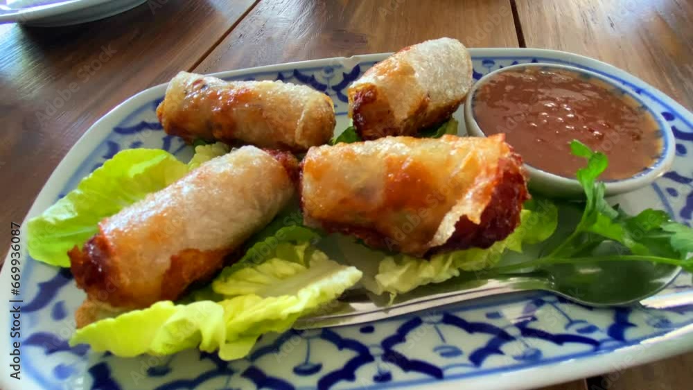 Traditional spring rolls on lettuce with sweet chili sauce in a Thai restaurant, tasty asian food, 4K shot Traditional spring rolls on lettuce with sweet chili sauce in a Thai restaurant, tasty asian food, 4K shot