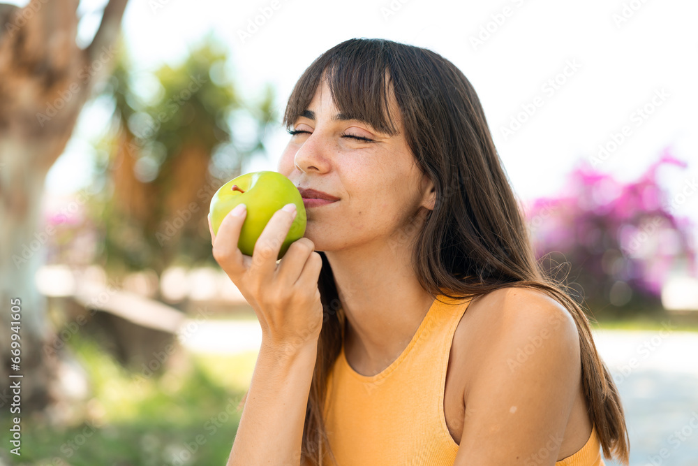 Young woman at outdoors holding an apple Young woman at outdoors holding an apple