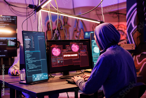 Εκτύπωση καμβά Criminal in hood successfully hacking into computer system in abandoned warehouse
