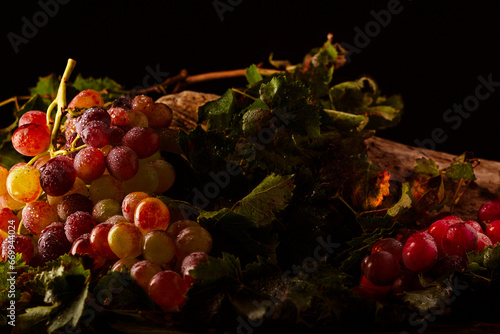 primer plano racimo de uvas rojas y verdes con hojas