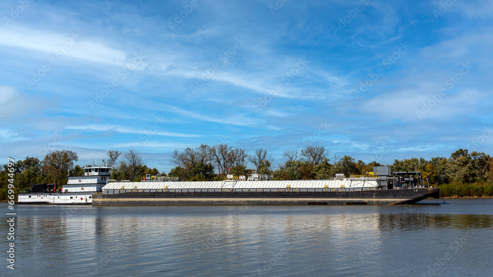 Obraz premium Barge traveling near the convergence of the Mississippi and Illinois Rivers