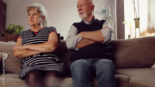 Elderly couple arguing while sitting on the sofa at home photo