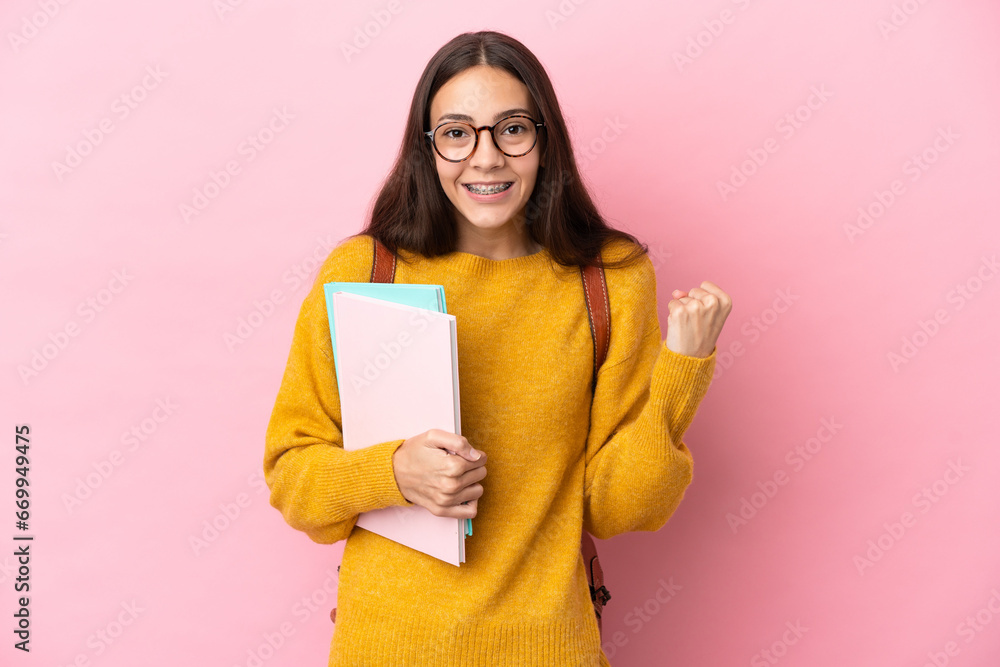 Young student woman over isolated background celebrating a victory in winner position Young student woman over isolated background celebrating a victory in winner position