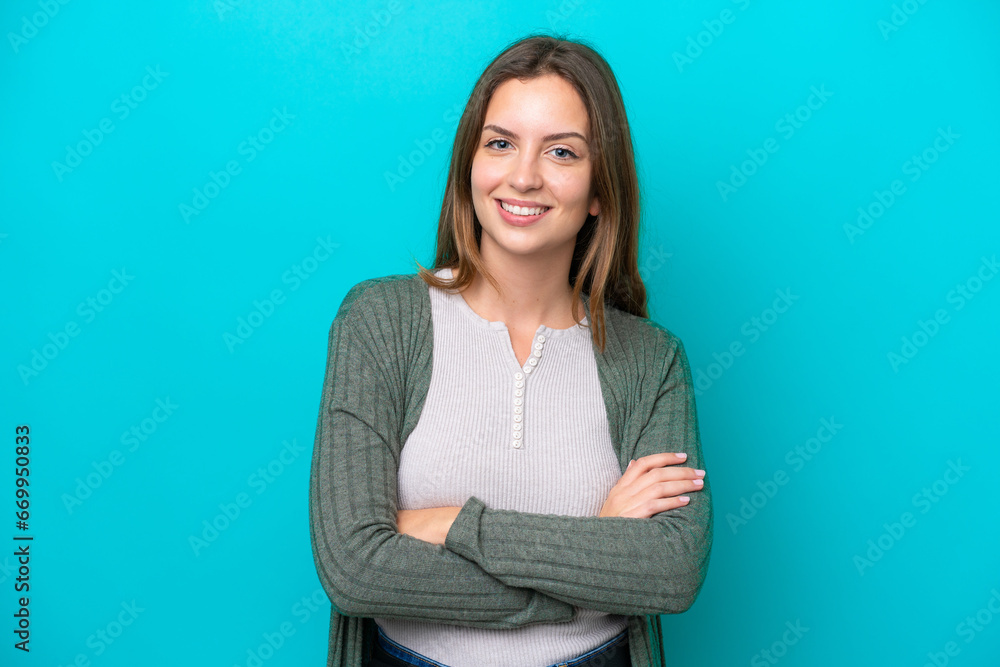 Young caucasian woman isolated on blue background keeping the arms crossed in frontal position Young caucasian woman isolated on blue background keeping the arms crossed in frontal position