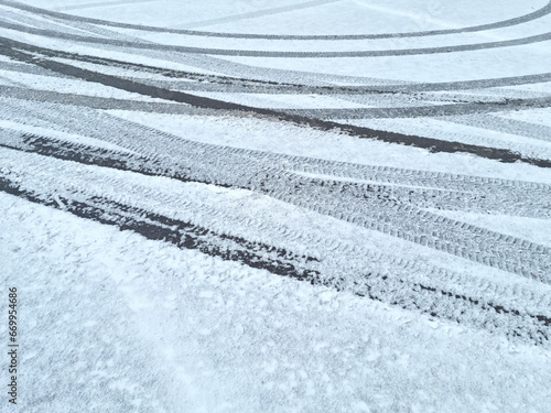 Dynamic car tread marks on the snow. Early winter. Energy and expression of movement. Black and white wheel print graphics