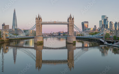 Tower Bridge  London England   reflected in the River Thames at sunrise with the city of London in the background including landmark buildings of the financial district