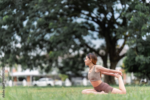 Asian woman wearing sportwear doing Yoga exercise in the nature © itchaznong
