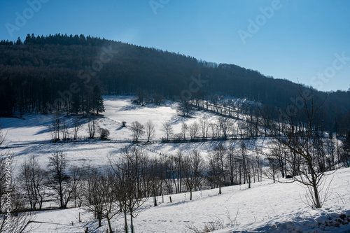 Landscape in winter with snow, sunlight and blue sky