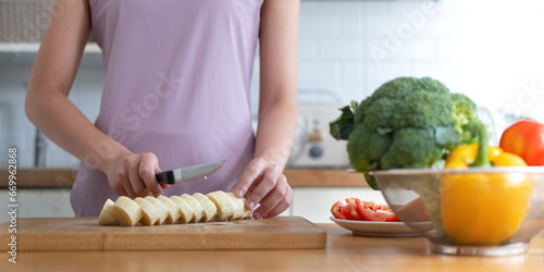Εκτύπωση καμβά Young healthy beautiful woman with casual clothes is smile and slicing fresh fru