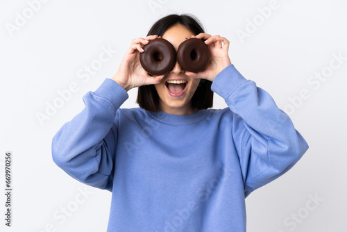 Young caucasian woman isolated on white background holding donuts in an eye