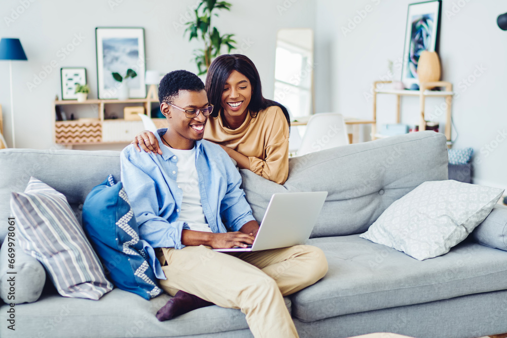 dark skinned romantic couple booking tickets for trip vacation together via netbook