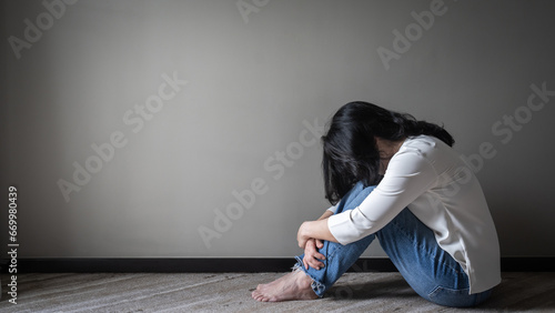 Anxiety disorder menopause woman, stressful depressed, panic attack person with mental health illness, headache and migraine sitting with back against wall on the floor in domestic home photo