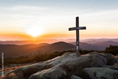 christian cross on top of a mountain with sunrise in background