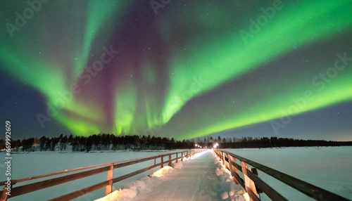 aurora borealis over a bridge in winter finnish lapland