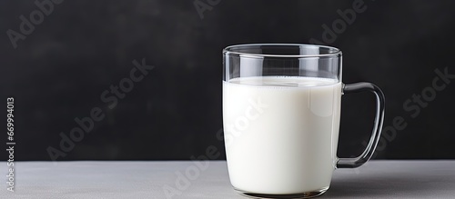 Close up of a milk filled glass mug on a gray background