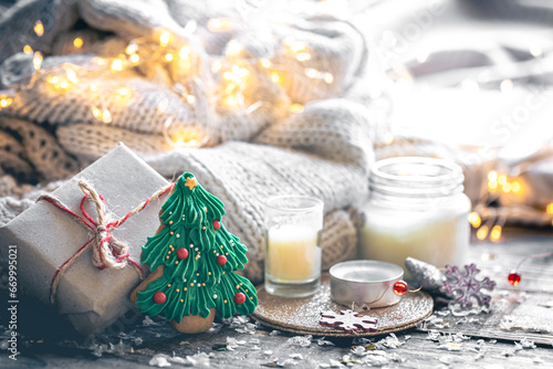 Cozy Christmas composition with gingerbread and candles on a blurred background.