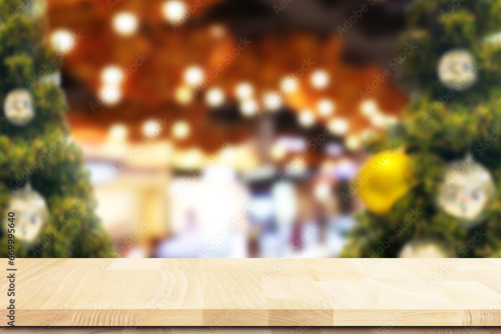Empty space of wooden textured table top with blurry  Christmas tree and New Year bokeh at winter night atmosphere festive interior  for presentation and advertising products background.