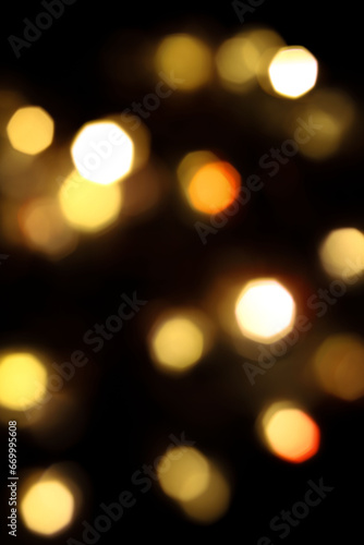 festive New Year's bokeh of warm yellow color, blurred on a dark background