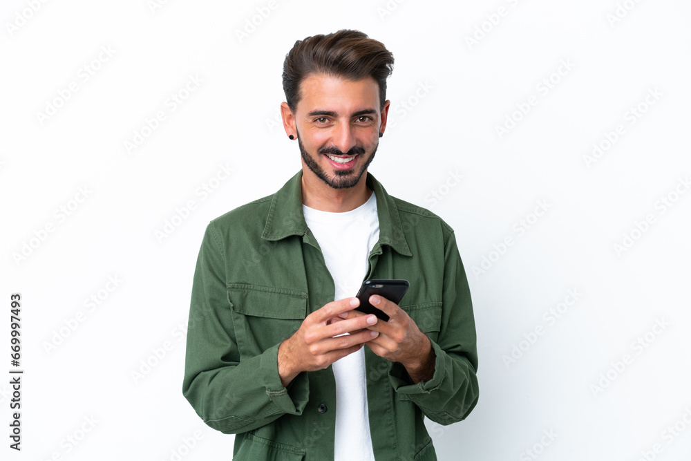 Young caucasian man isolated on white background sending a message with the mobile Young caucasian man isolated on white background sending a message with the mobile