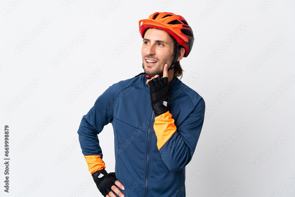 Young cyclist man isolated on white background thinking an idea while looking up Young cyclist man isolated on white background thinking an idea while looking up