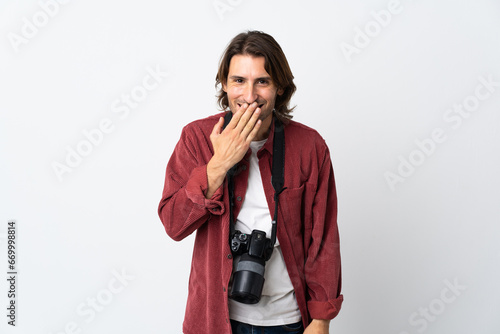 Young photographer man isolated on white background happy and smiling covering mouth with hand