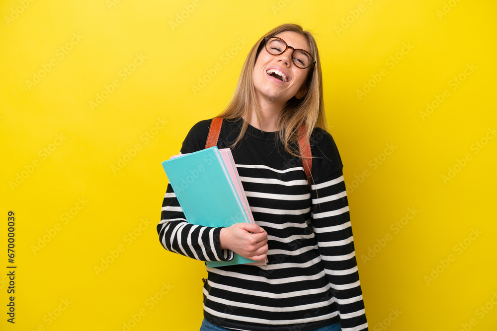 Young student woman isolated on yellow background background laughing Young student woman isolated on yellow background background laughing