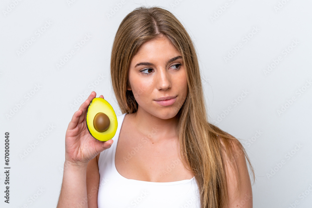 Young caucasian woman isolated on white background holding an avocado. Close up portrait Young caucasian woman isolated on white background holding an avocado. Close up portrait