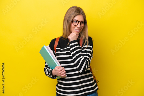 Young student woman isolated on yellow background background looking to the side and smiling
