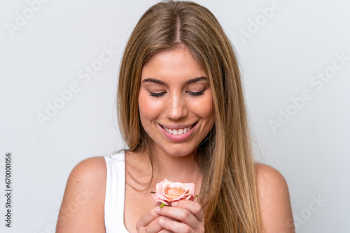 Young caucasian woman isolated on white background holding flowers with happy expression. Close up portrait