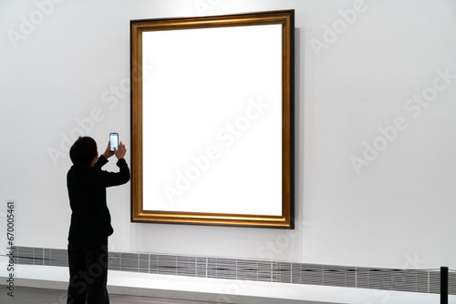 Audiences looking at oil paintings in gallery