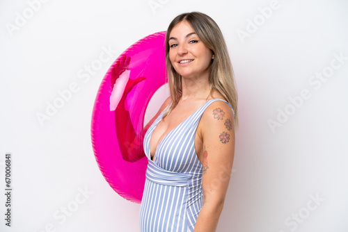 Young Rumanian woman in swimsuit holding a air mattress donut isolated on white background smiling a lot